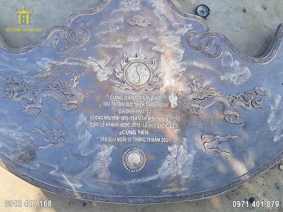 Tr&ecirc;n bề mặt kh&aacute;nh đồng chạm khắc t&ecirc;n gia đ&igrave;nh gia chủ c&uacute;ng tiến v&ocirc; c&ugrave;ng sắc n&eacute;t